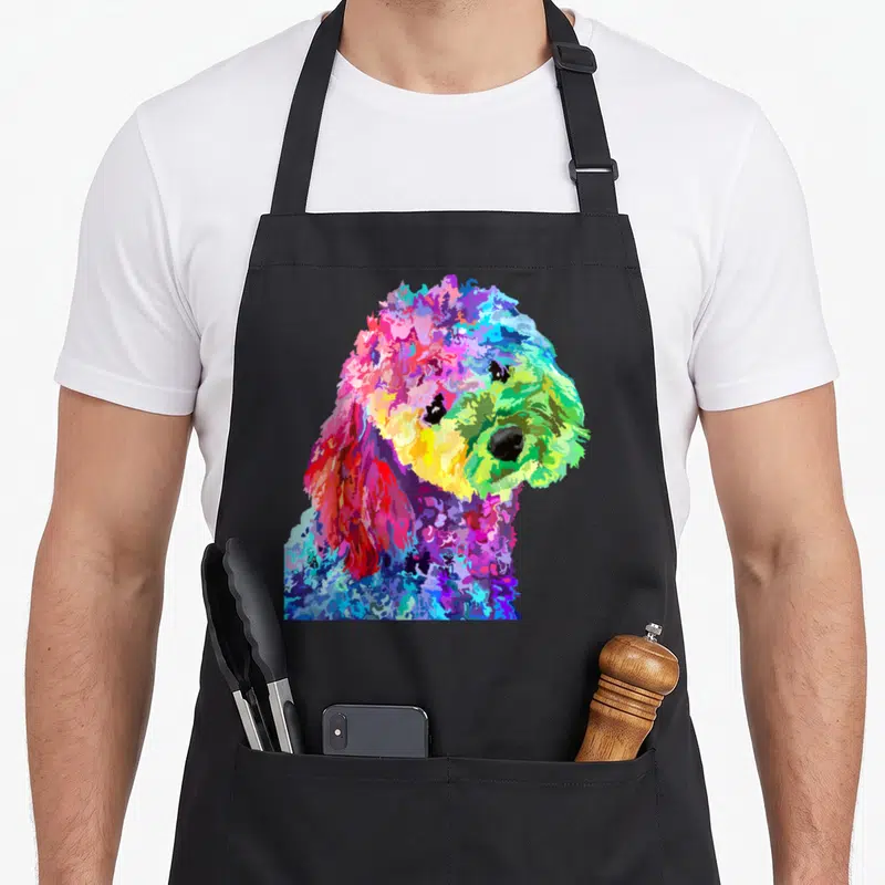 Colorful poodle dog apron - Rainbow cartoon poodle head and shoulders in pink blue yellow green purple — shown on a black cotton canvas apron against a white background