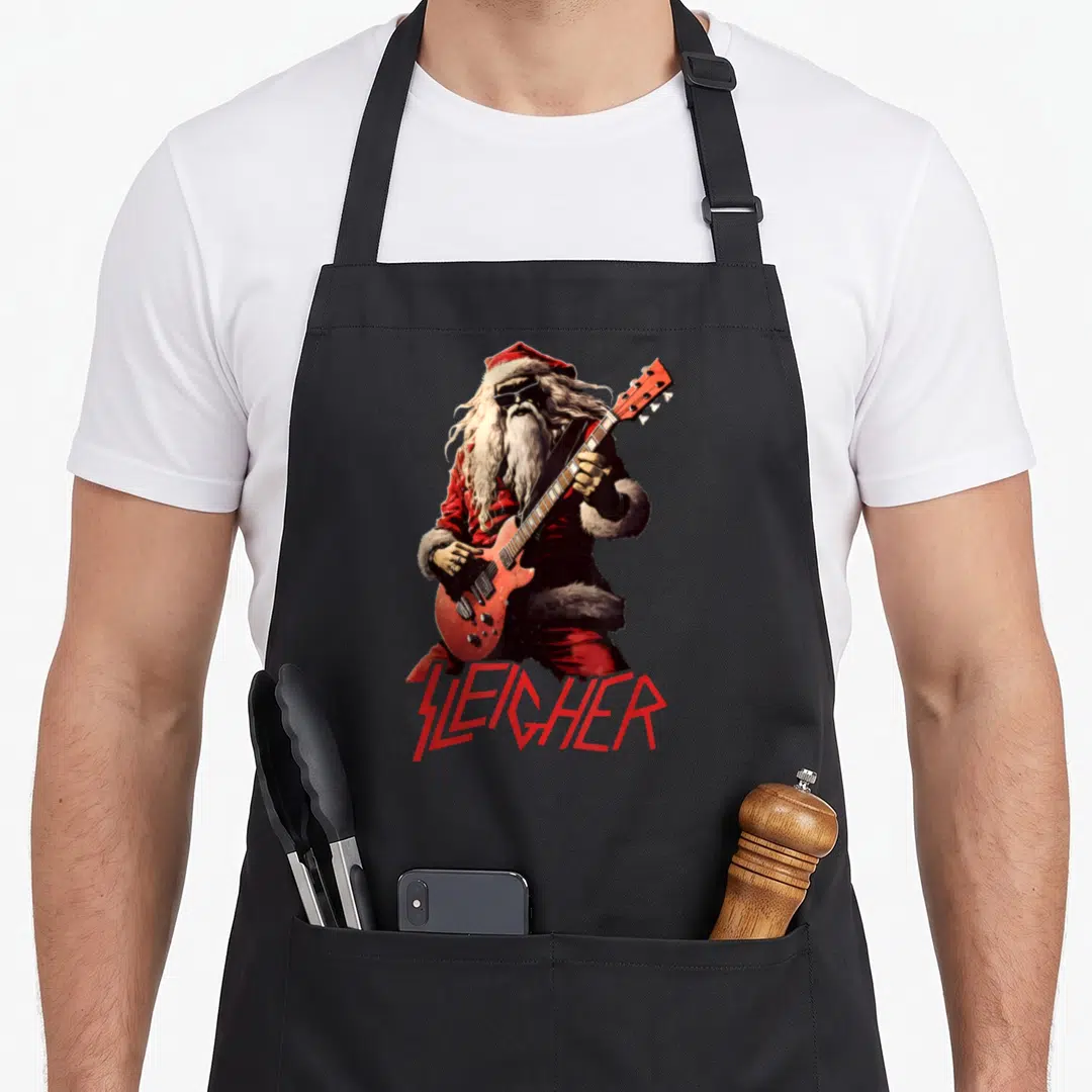 Christmas heavy metal apron - Realistic Santa playing red guitar with Sleighher text in heavy metal font — shown on a black cotton canvas apron against a white background