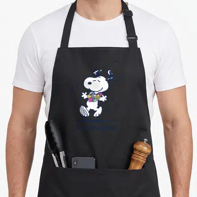 Cute beach apron - Snoopy wearing a yellow and pink flower lei with dark blue text TAKE ME TO THE BEACH — shown on a black cotton canvas apron against a white background