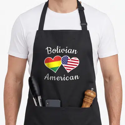 Bolivia bolivian apron - Two hearts filled with red yellow green and blue flag stripes under Bolivian American text — shown on a black cotton canvas apron against a white background