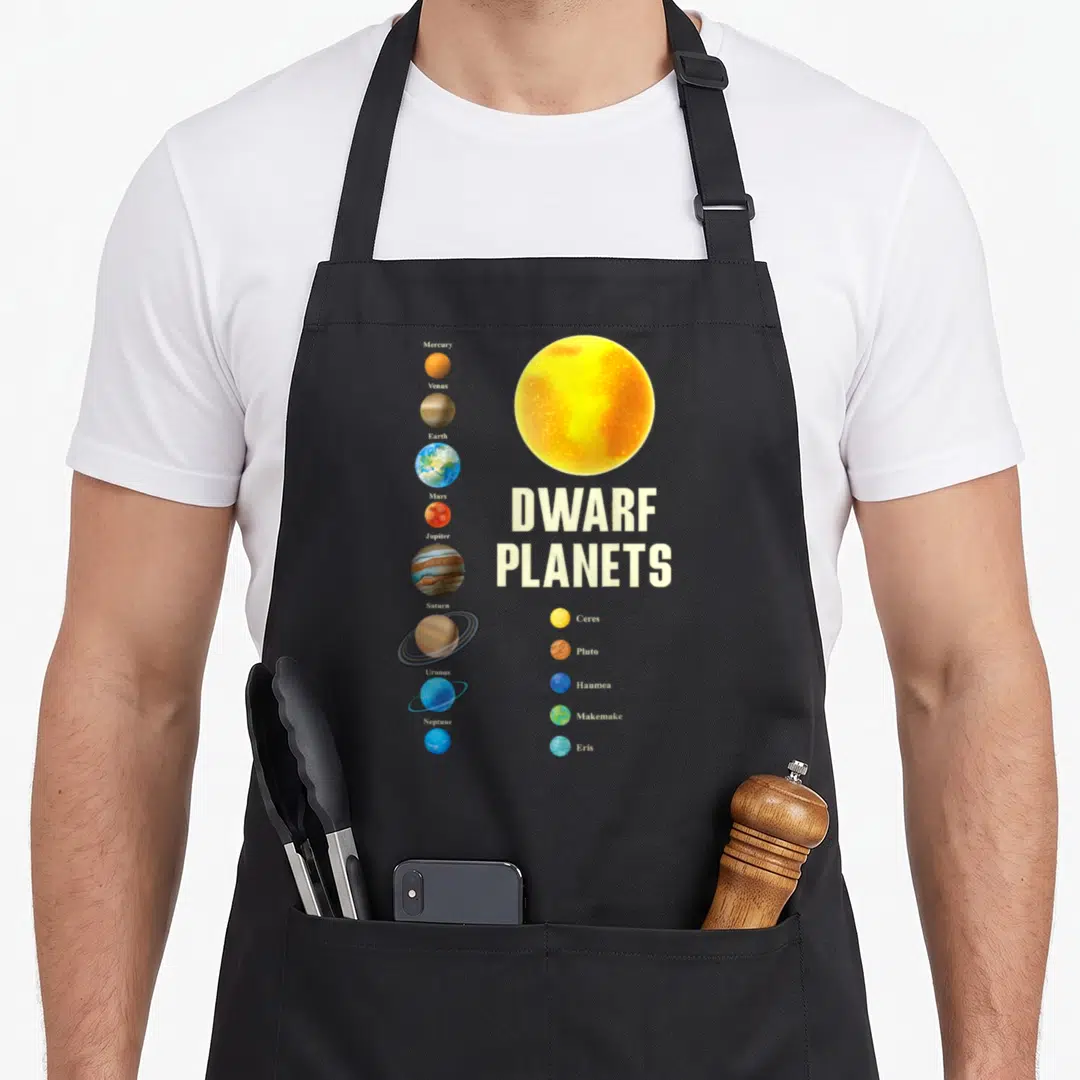 Dwarf space planets apron - Solar system chart with eight planets and five dwarf planets labeled next to a large yellow — shown on a black cotton canvas apron against a white background
