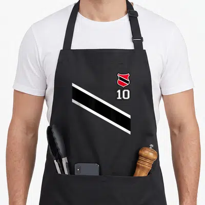 Trinidad football apron - Red and black crest above number 10 with diagonal stripe on black fabric — shown on a black cotton canvas apron against a white background