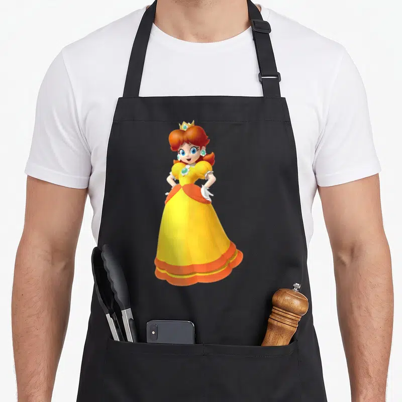 Princess daisy apron - Cartoon Princess Daisy in yellow dress with orange sash and white gloves on black background — shown on a black cotton canvas apron against a white background