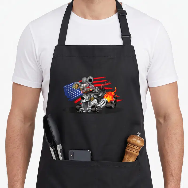 Digirod cartoon apron - Grey monster drives black hot rod with USA flag and orange flames in cartoon style using black — shown on a black cotton canvas apron against a white background
