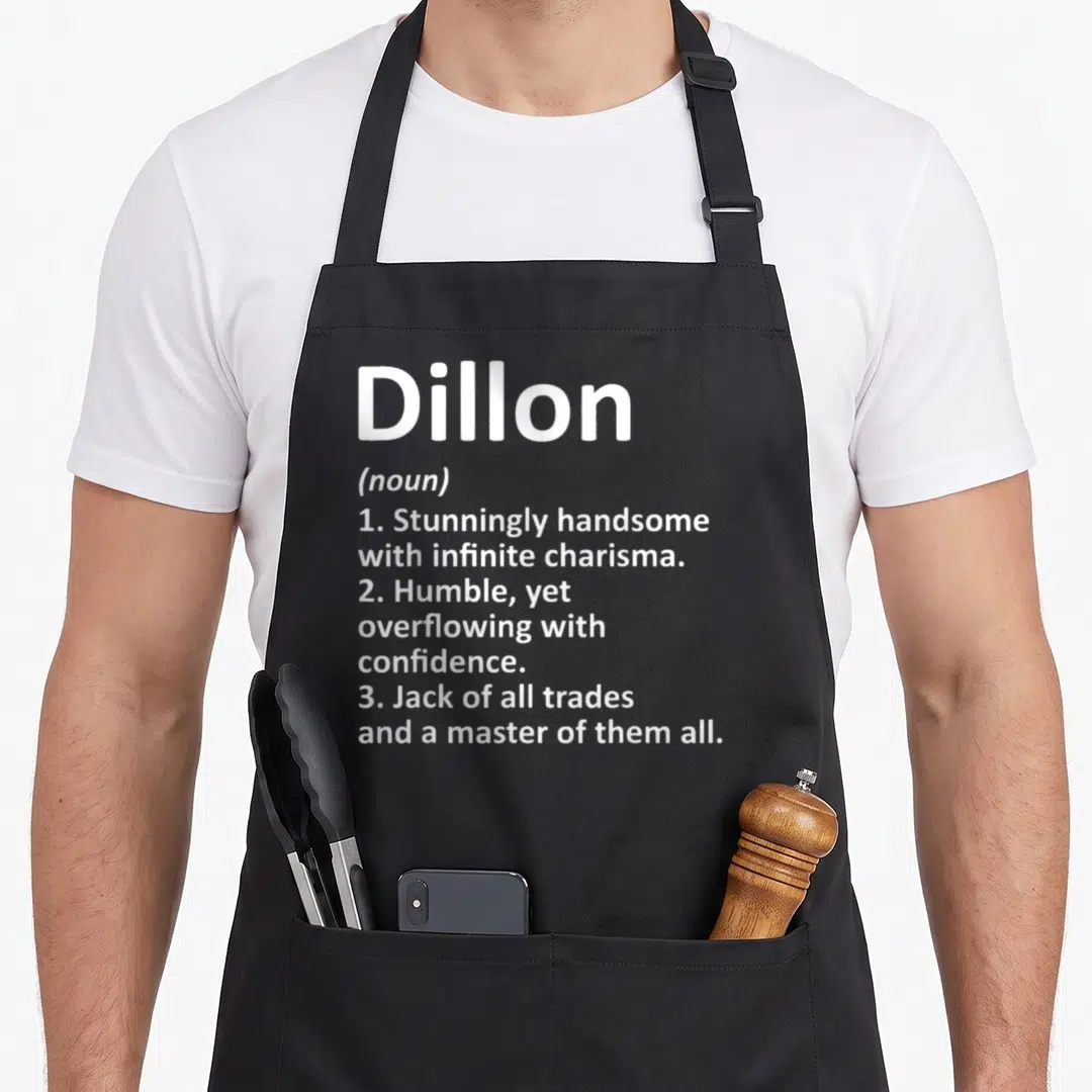 Dillon father day aprons - White dictionary style text defining Dillon as handsome humble and master of all trades — shown on a black cotton canvas apron against a white background