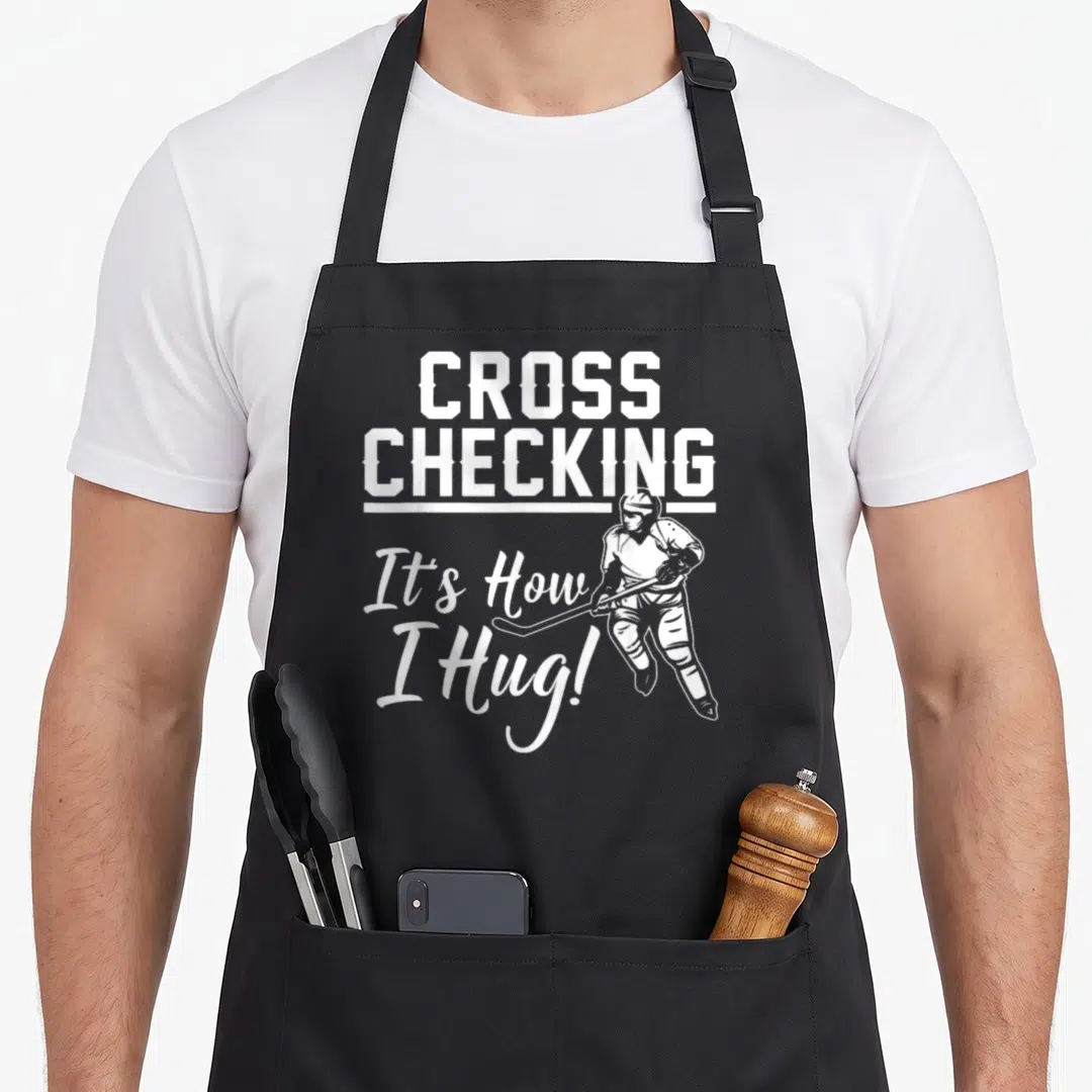 Ice game aprons - White crossed text and hockey player line art on grey background — shown on a black cotton canvas apron against a white background