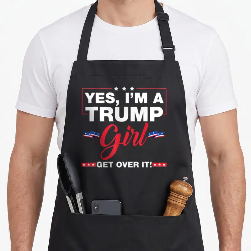 Election novelty apron - Stacked text Yes I'm A Trump Girl Get Over It with stars and flags — shown on a black cotton canvas apron against a white background
