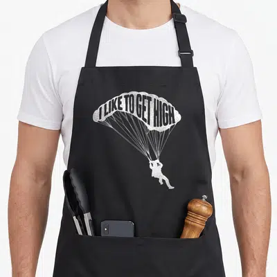 Skydiving parachute apron - White parachute canopy with I LIKE TO GET HIGH text above skydiver silhouette — shown on a black cotton canvas apron against a white background
