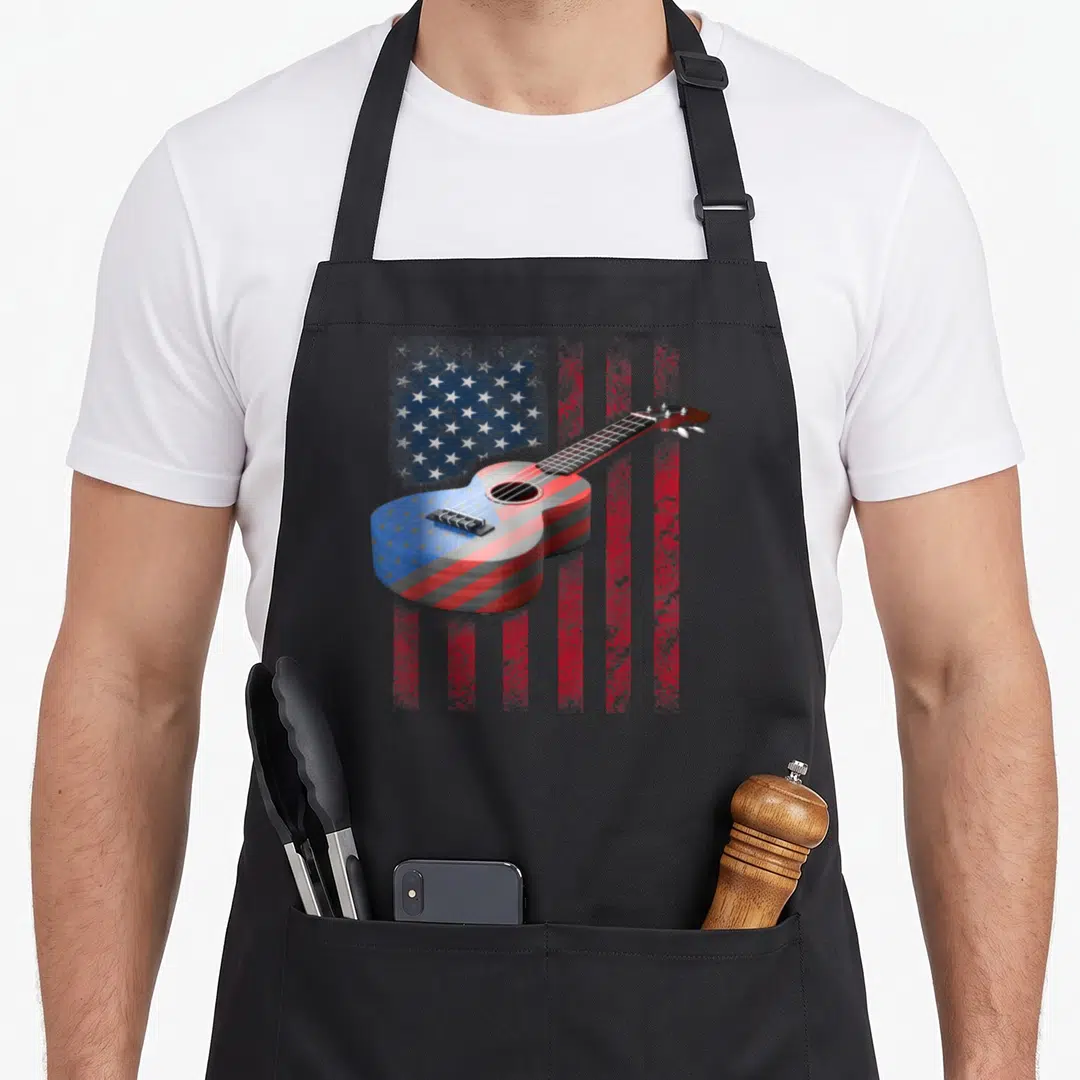 Acoustic american flag apron - Ukulele with red white blue flag pattern on distressed background — shown on a black cotton canvas apron against a white background