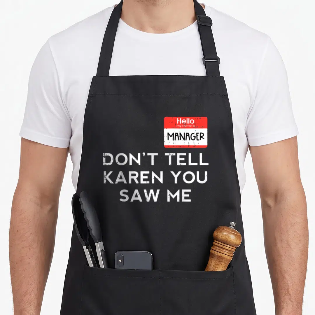 Manager karen halloween apron - Distressed name tag reading Manager and text Don't Tell Karen You Saw Me in white — shown on a black cotton canvas apron against a white background