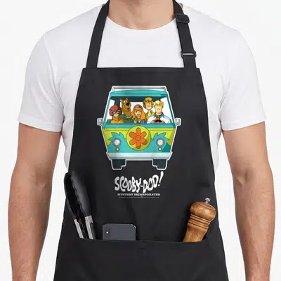 Incorporated machine apron - Mystery Machine van with characters and white text in lime green blue and orange cartoon — shown on a black cotton canvas apron against a white background