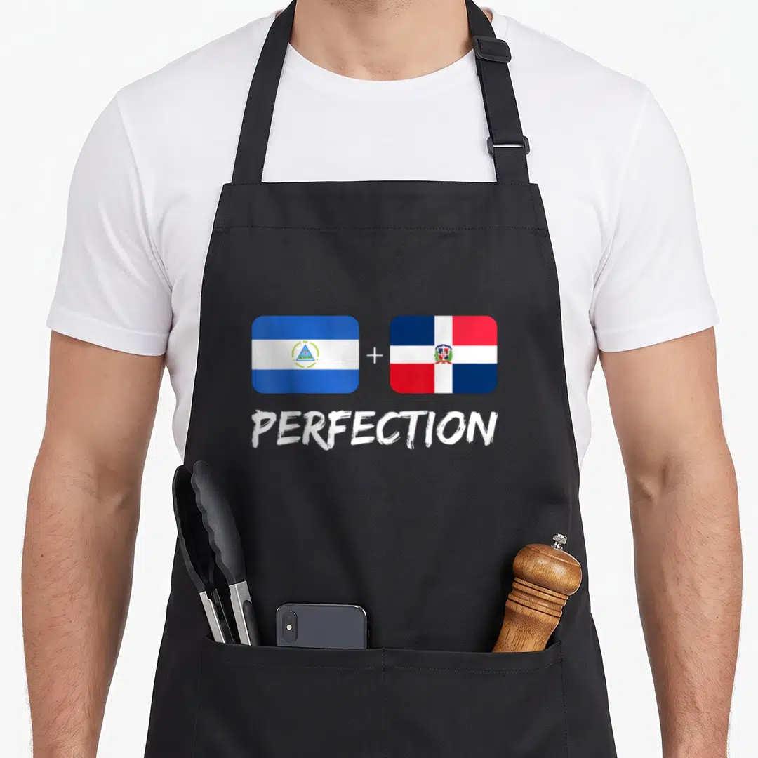 Perfection flag heritage aprons - Two flags with plus sign and word PERFECTION in blue white red — shown on a black cotton canvas apron against a white background