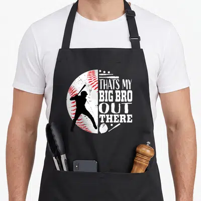Bro baseball apron - Split baseball graphic with batter silhouette and That's My Big Bro Out There text — shown on a black cotton canvas apron against a white background