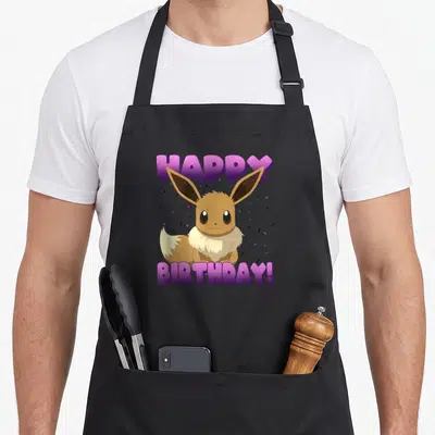 Pok custom face apron - Cartoon Eevee sitting between purple Happy Birthday text and scattered confetti — shown on a black cotton canvas apron against a white background