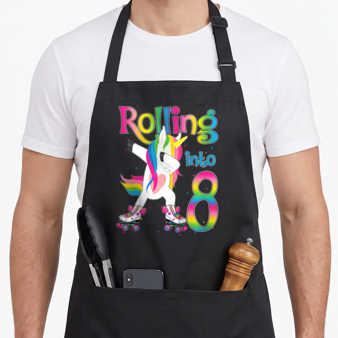 Roll roller turning apron - Dabbing unicorn on roller skates with rainbow Rolling into 8 text — shown on a black cotton canvas apron against a white background