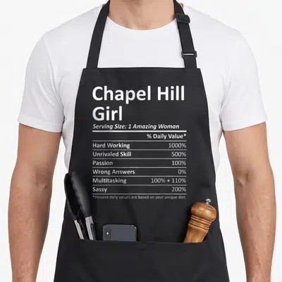 Hill chapel apron - White nutrition label text for Chapel Hill Girl listing sassy and hard working percentages — shown on a black cotton canvas apron against a white background