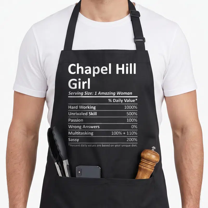 Hill chapel apron - White nutrition label text for Chapel Hill Girl listing sassy and hard working percentages — shown on a black cotton canvas apron against a white background