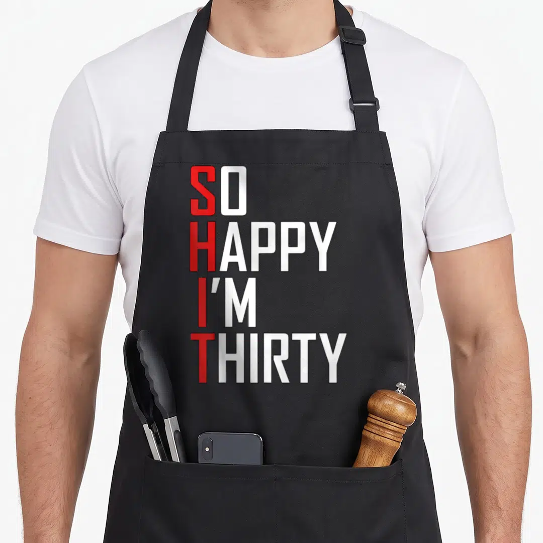 Thirty gag aprons - Stacked red and white text reading so happy i'm thirty with vertical hidden word — shown on a black cotton canvas apron against a white background
