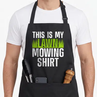 Groundskeeper landscaper apron - Stacked text THIS IS MY LAWN MOWING SHIRT with green grass blades filling the middle — shown on a black cotton canvas apron against a white background