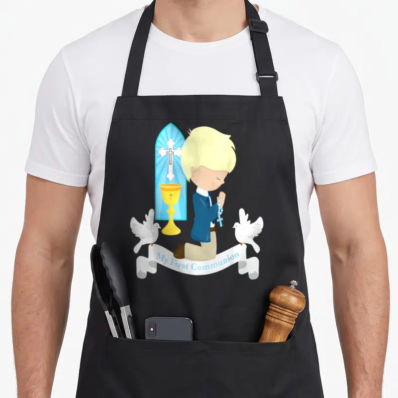 Blonde communion aprons - Kneeling boy in blue suit with gold chalice, two white doves, stained glass cross, and My — shown on a black cotton canvas apron against a white background