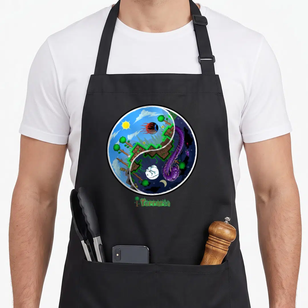 Terraria logic apron - Circular yin yang with day landscape red eye and night purple worm below Terraria logo — shown on a black cotton canvas apron against a white background