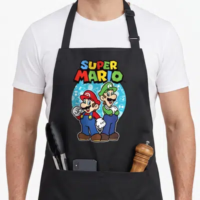Ready big brother apron - Super Mario text and two cartoon figures in front of a blue circle with icons — shown on a black cotton canvas apron against a white background