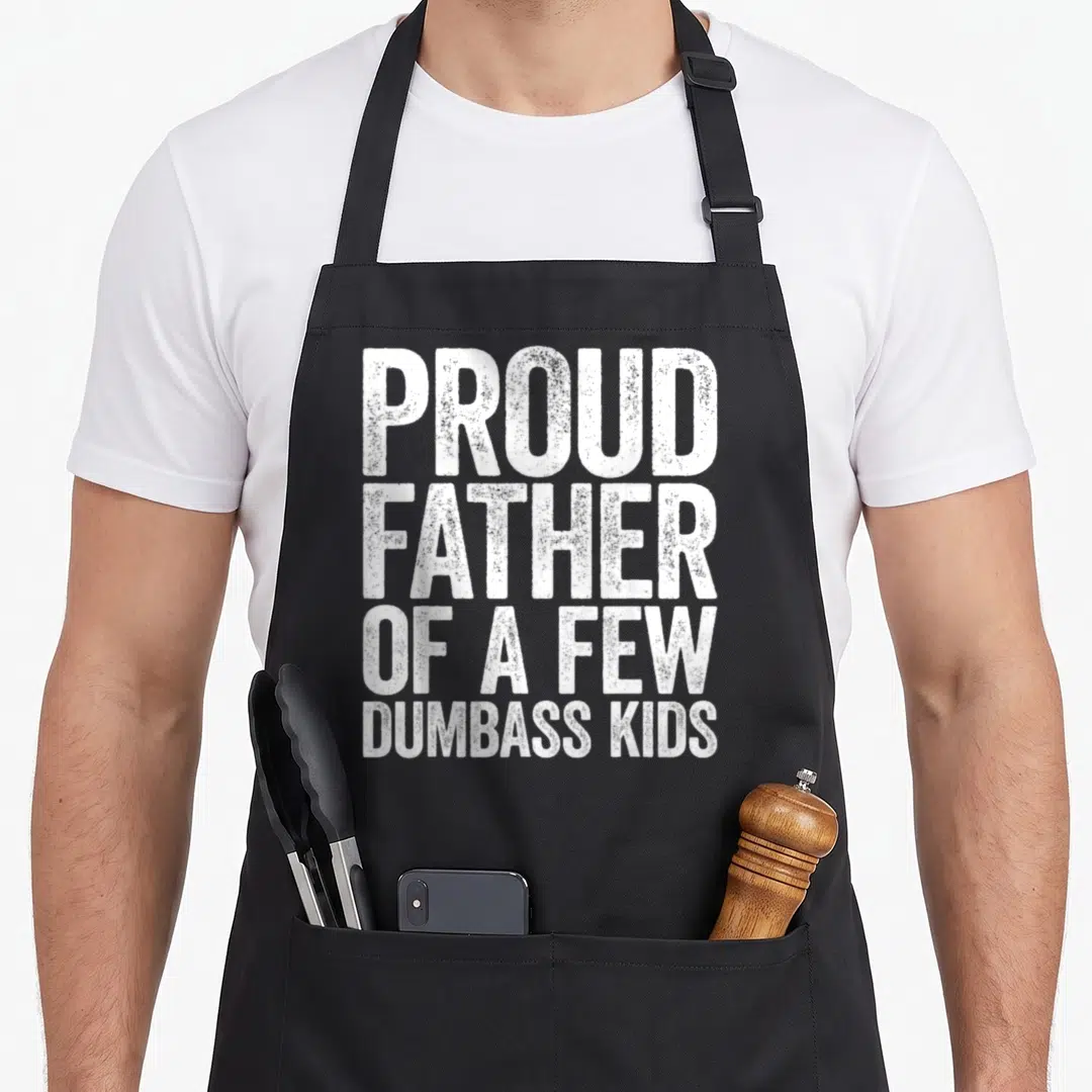 Dumbass father day apron - White stacked text reading PROUD FATHER OF A FEW DUMBASS KIDS — shown on a black cotton canvas apron against a white background