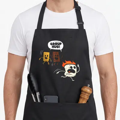 Marshmallow camping apron - Cartoon sponge and chocolate hugging while a flaming marshmallow runs away under text — shown on a black cotton canvas apron against a white background