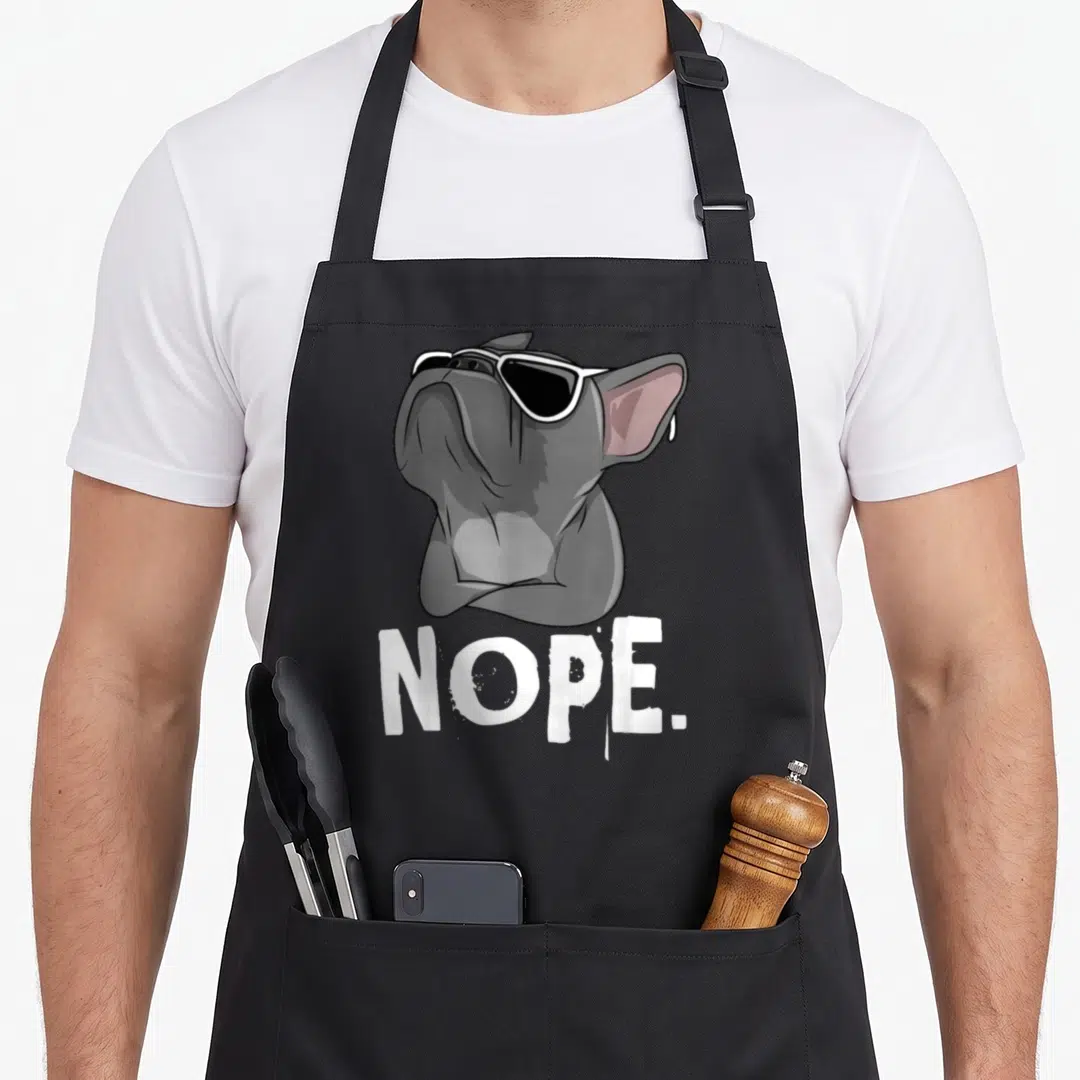 Nope french bulldog apron - Cartoon grey french bulldog in sunglasses above white nope text — shown on a black cotton canvas apron against a white background