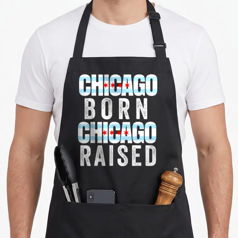 Flag illinois chicago apron - Stacked text Chicago Born Chicago Raised with flag stripes and stars in white blue red — shown on a black cotton canvas apron against a white background