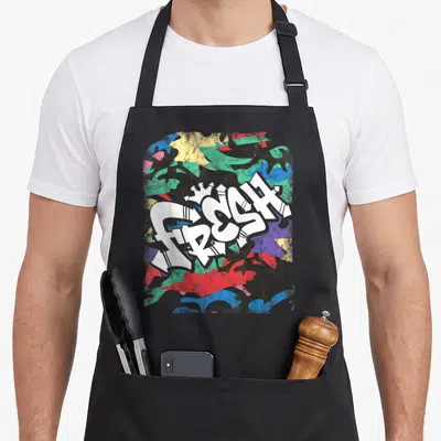 Hip urban apron - White FRESH graffiti text with crown over blue green red yellow black camouflage pattern — shown on a black cotton canvas apron against a white background