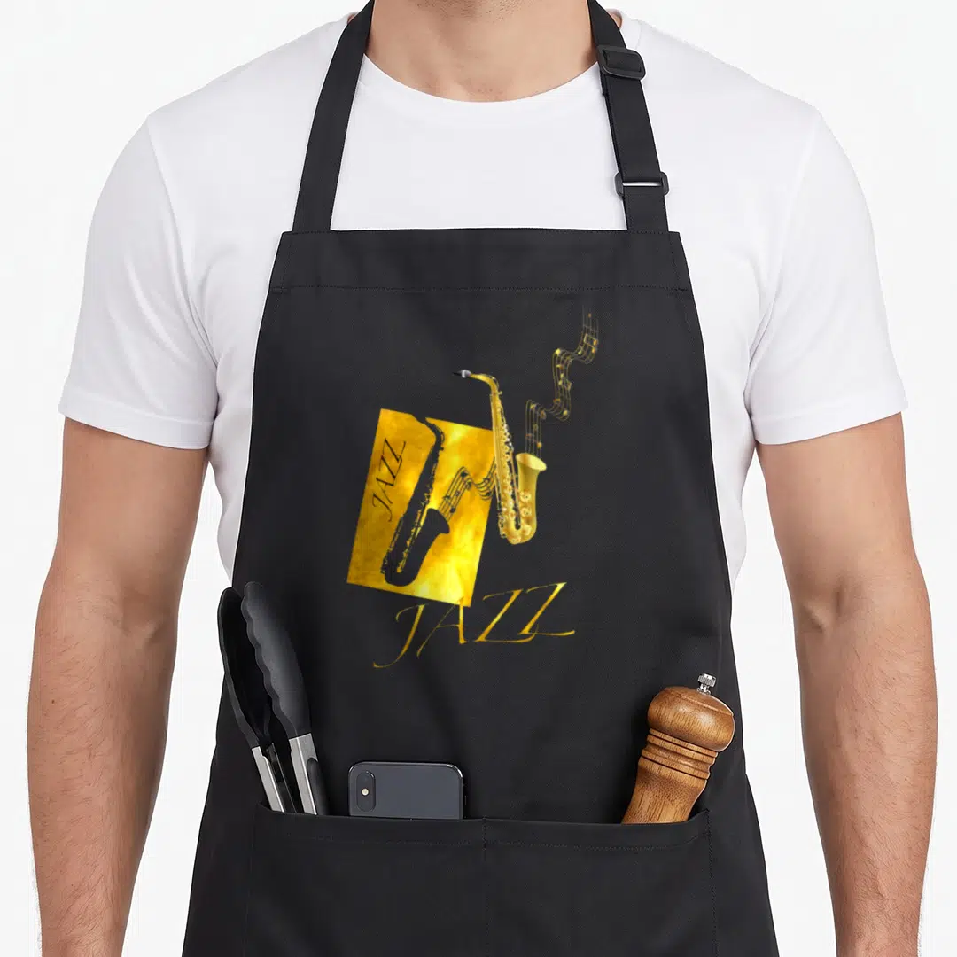 Jazz world music apron - Gold saxophone with musical notes and JAZZ text on black background — shown on a black cotton canvas apron against a white background