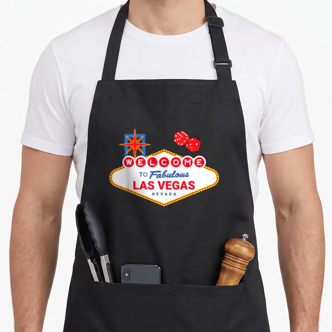 Welcome vegas girls apron - Welcome to Fabulous Las Vegas sign with red dice and star — shown on a black cotton canvas apron against a white background