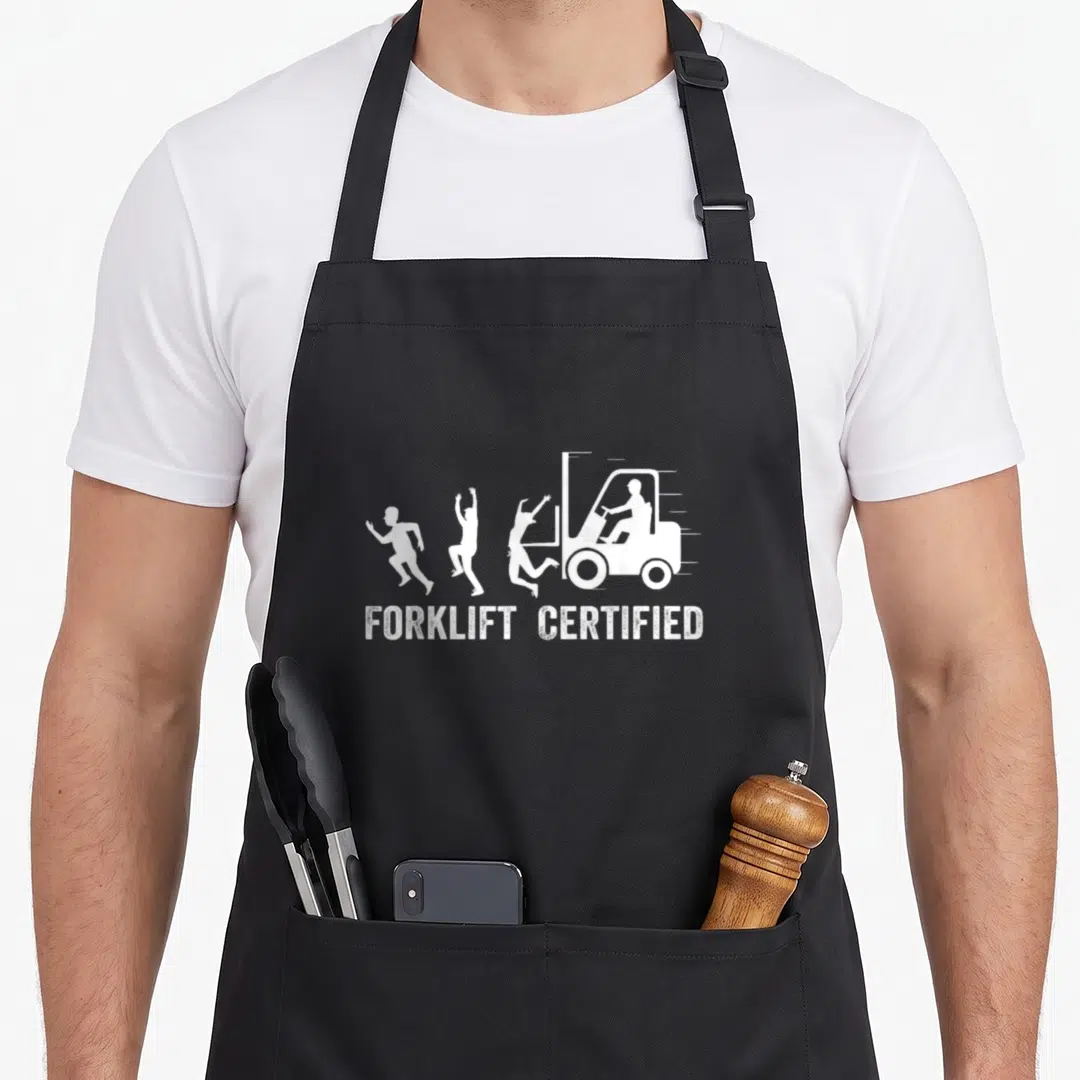 Driver forklift guy apron - White forklift chasing three running people with text forklift certified below — shown on a black cotton canvas apron against a white background