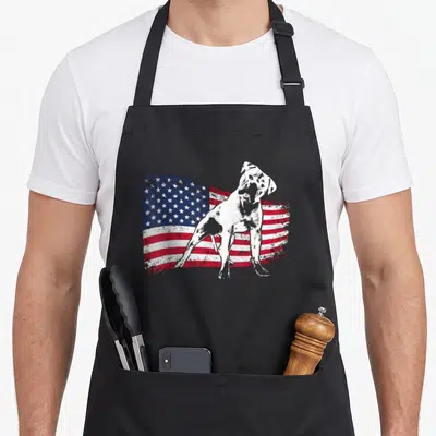 Cute bulldog southern aprons - White dog silhouette standing before distressed American flag in red white blue — shown on a black cotton canvas apron against a white background