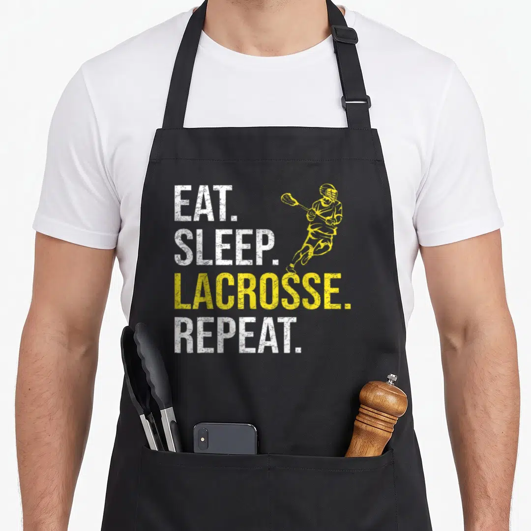 Eat father day apron - EAT SLEEP LACROSSE REPEAT text with running yellow player silhouette in distressed style — shown on a black cotton canvas apron against a white background