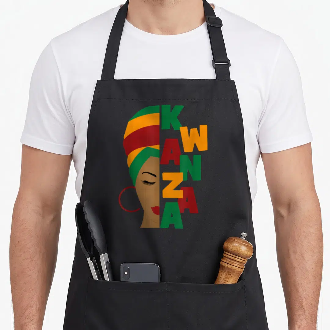Turban african apron - Woman profile with striped headwrap and vertical KWANZA text in green yellow red brown — shown on a black cotton canvas apron against a white background