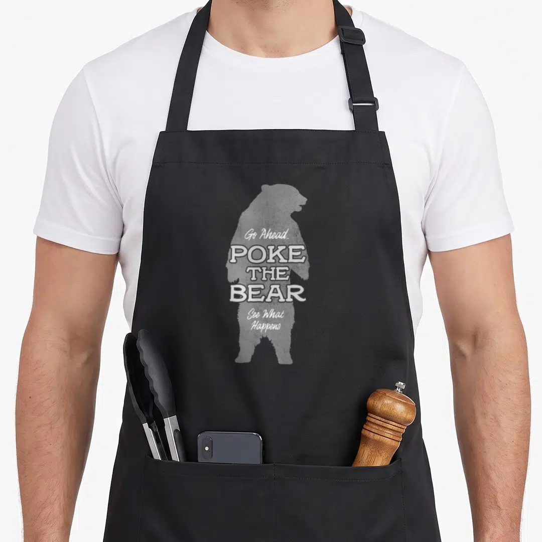 Ahead morning run apron - Grey bear silhouette with white text Go Ahead Poke the Bear See What Happens — shown on a black cotton canvas apron against a white background