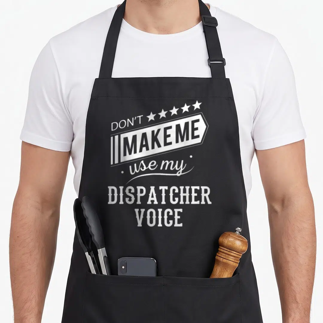 Dispatcher use of apron - White and grey typography reading Don't Make Me Use My Dispatcher Voice with five stars — shown on a black cotton canvas apron against a white background