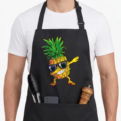 Dabbing pineapple apron - Cartoon pineapple wearing black sunglasses and red flip-flops in a dab pose — shown on a black cotton canvas apron against a white background