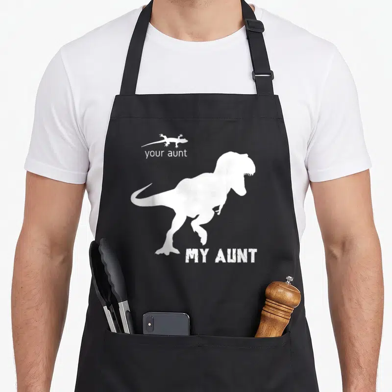 Squad best aunt ever apron - White T-Rex and lizard silhouettes with your aunt MY AUNT text on black — shown on a black cotton canvas apron against a white background