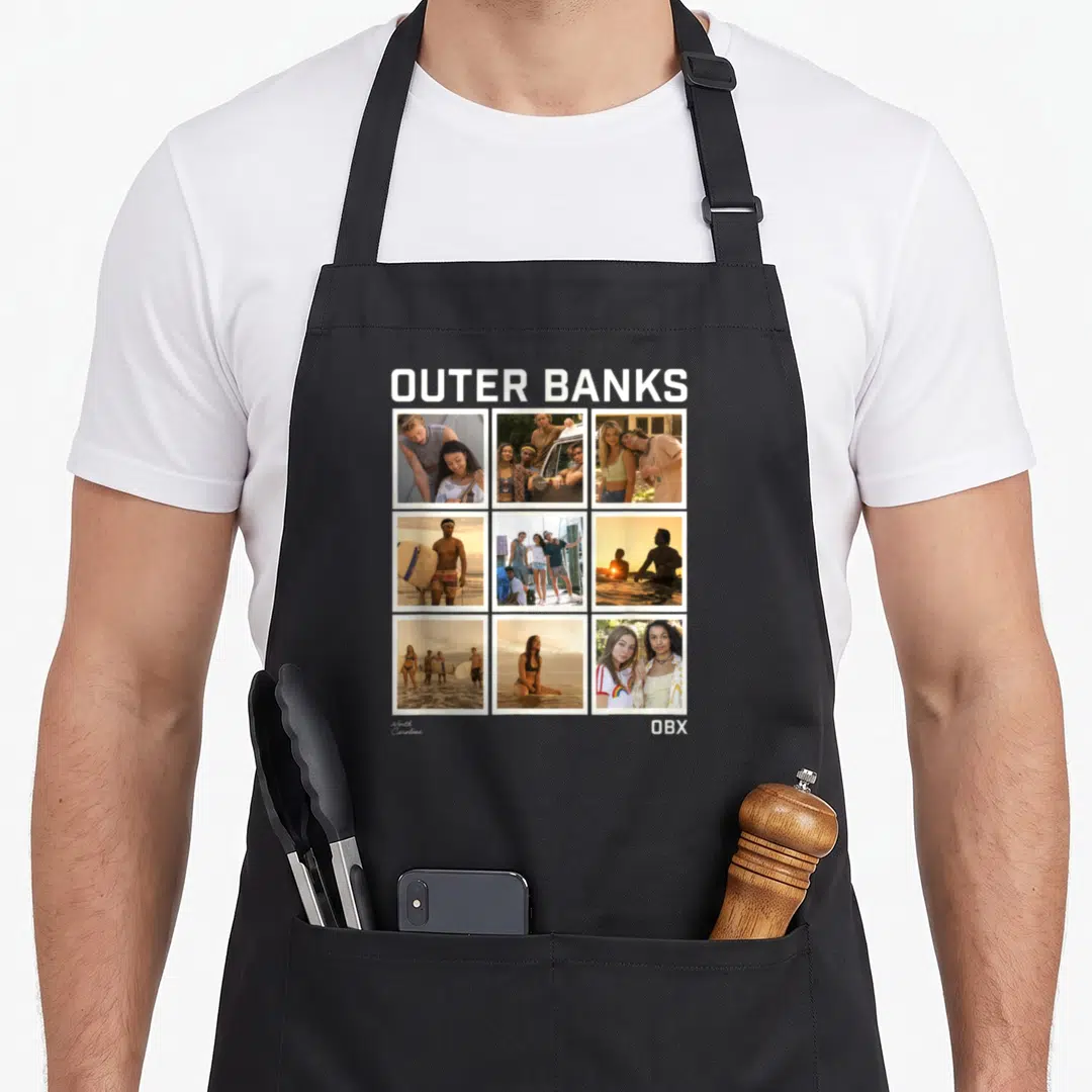 Outer photo collage apron - Outer Banks text above 3x3 cast photo grid with North Carolina and OBX labels — shown on a black cotton canvas apron against a white background