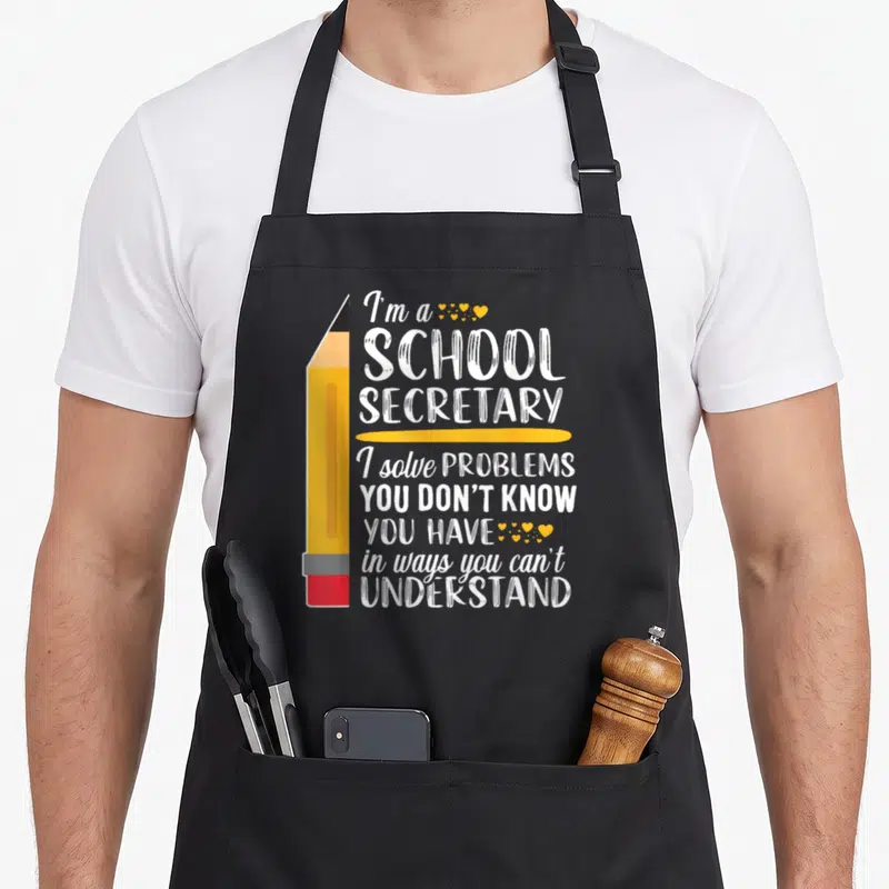 Clerk office apron - Yellow pencil next to white text about solving problems with small hearts — shown on a black cotton canvas apron against a white background