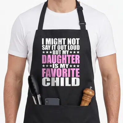 Daughter i love colorado apron - White and pink stacked text reading I might not say it out loud but my daughter is my — shown on a black cotton canvas apron against a white background