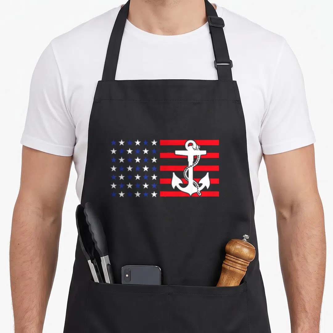 Anchor patriotic apron - White anchor and rope over red white blue star and stripe pattern — shown on a black cotton canvas apron against a white background
