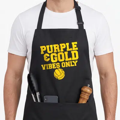 School volleyball game aprons - Yellow PURPLE & GOLD VIBES ONLY text and volleyball graphic on grey canvas — shown on a black cotton canvas apron against a white background