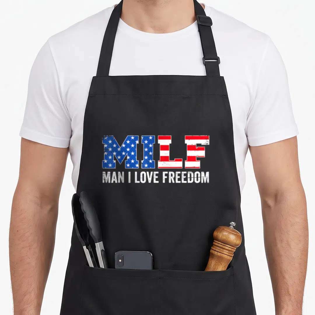 Milf freedom 4th of july apron - Red white and blue distressed flag text reading MILF MAN I LOVE FREEDOM — shown on a black cotton canvas apron against a white background