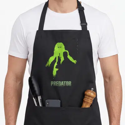 Predator dutch apron - Green Predator silhouette with vertical symbols and PREDATOR text — shown on a black cotton canvas apron against a white background
