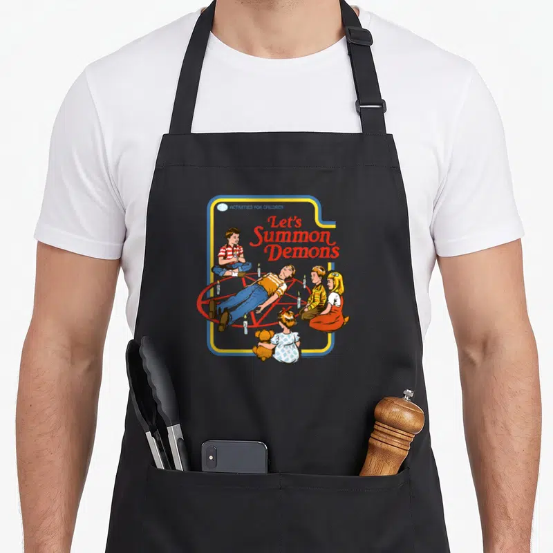 Summon steven rhodes apron - Retro illustration of children summoning demons around a red pentagram with candles — shown on a black cotton canvas apron against a white background