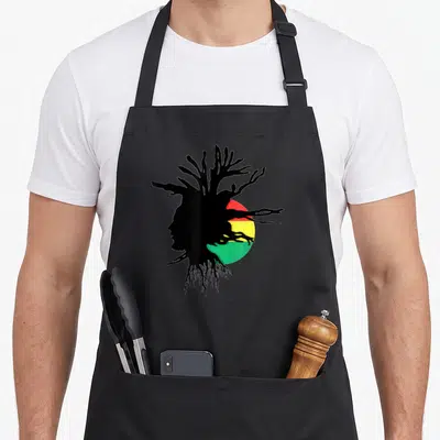 Rasta ethiopian boy apron - Black male profile silhouette with branch hair over red yellow green circle — shown on a black cotton canvas apron against a white background